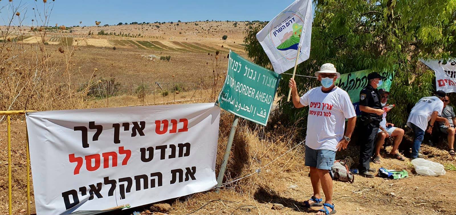 מפגין עם דגל דרום השרון במחאת החקלאים
