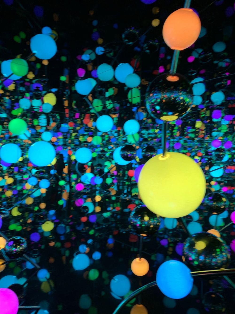 נקודות צבעוניות מוארות במיצג בתערוכה של האומנית קוסאמה