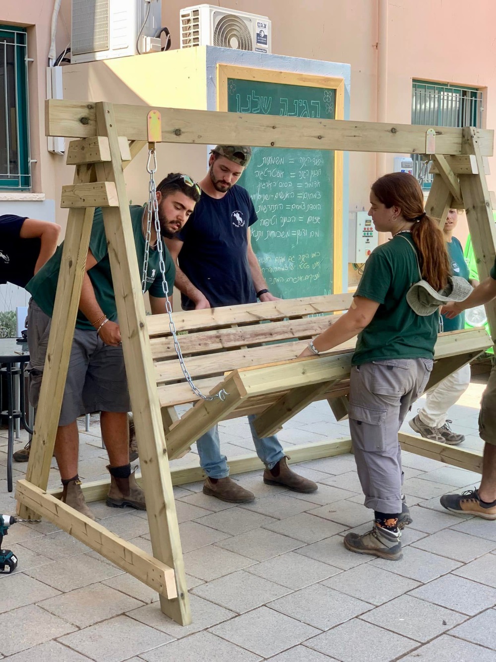 חונכים את הגינה החדשה בדרום השרון ומציבים ספסל נדנדה מעץ