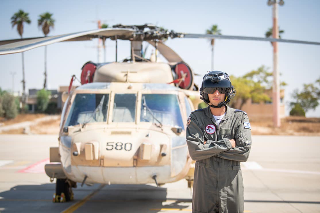 אחד מהטייסים החדשים תושב דרום השרון בטקס הסיום על רקע מסוק צבאי