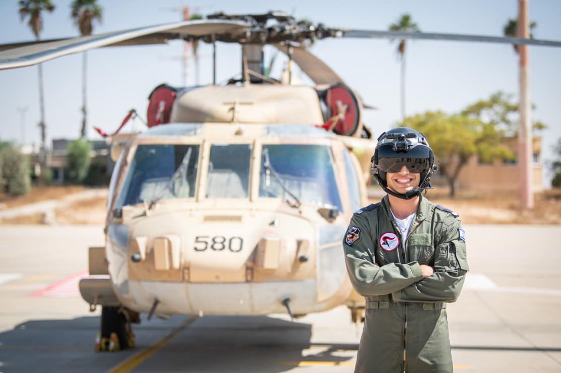 אחד מהטייסים החדשים תושב דרום השרון בטקס הסיום על רקע מסוק צבאי