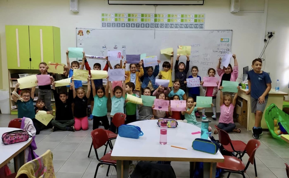 תלמידי יסודי מציגים כרזות הסברה במסגרת פעילות שבוע מניעת אלימות בבית הספר