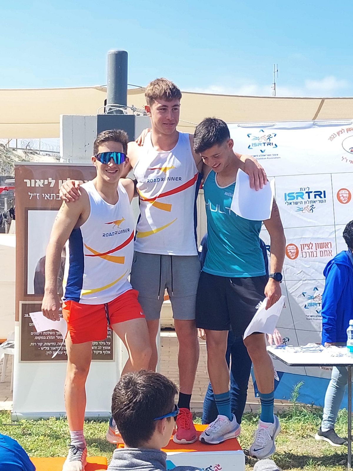 תמונה של מעין גלנץ עומד על פודיום הזוכים