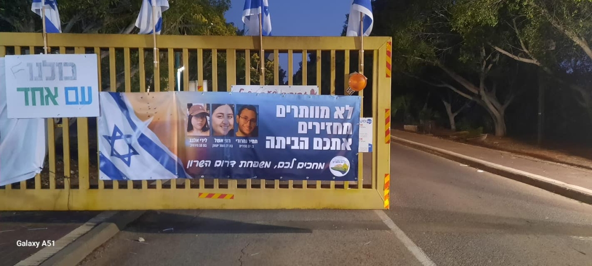 תמונה של כרזה למען שחרור החטופים תלויה בכניסות ליישובי המועצה השונים