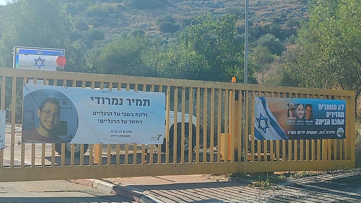 תמונה של כרזה למען שחרור החטופים תלויה בכניסות ליישובי המועצה השונים