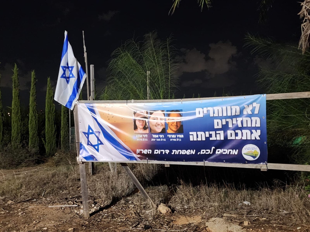 תמונה של כרזה למען שחרור החטופים תלויה בכניסות ליישובי המועצה השונים