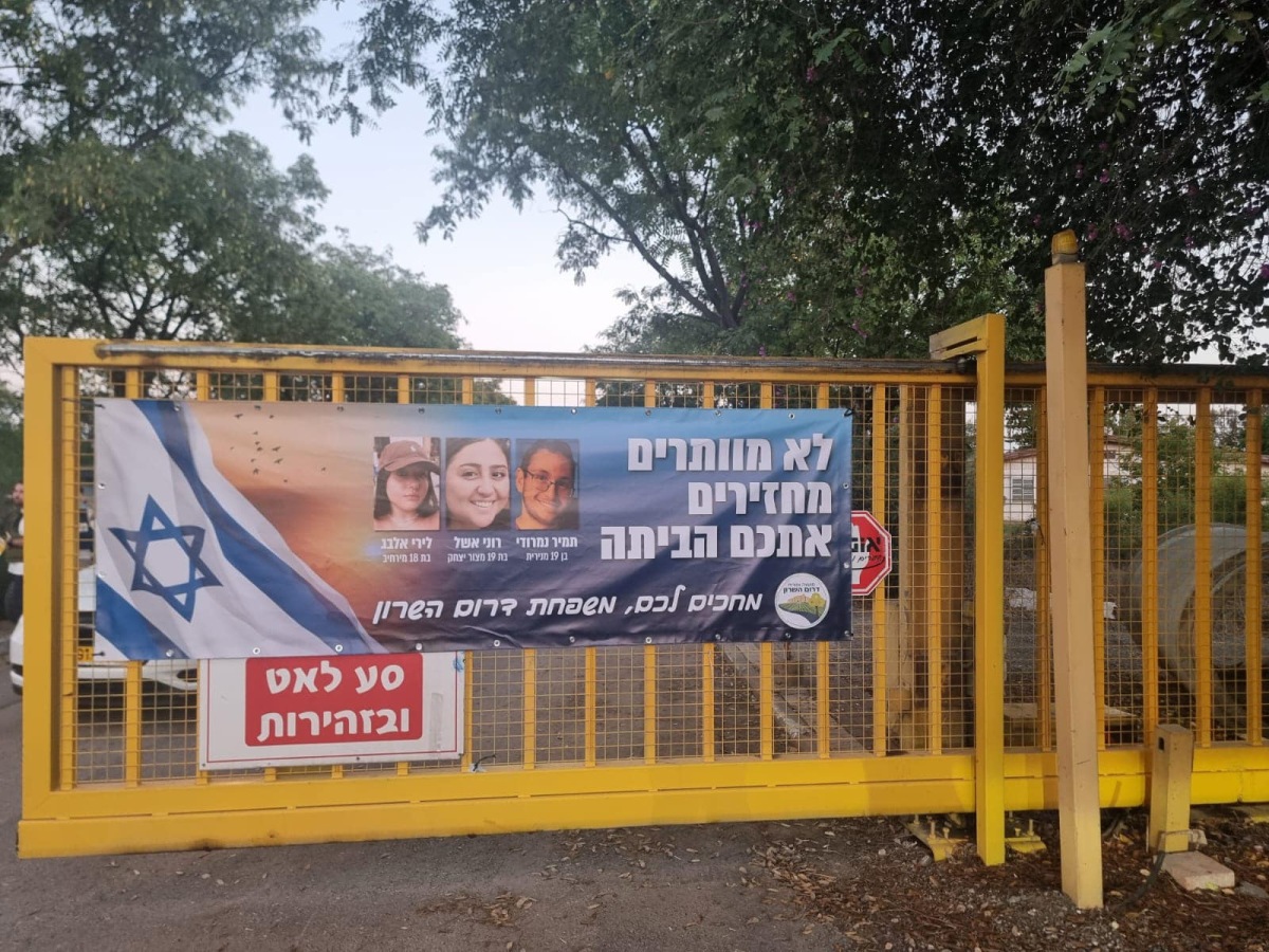 תמונה של כרזה למען שחרור החטופים תלויה בכניסות ליישובי המועצה השונים