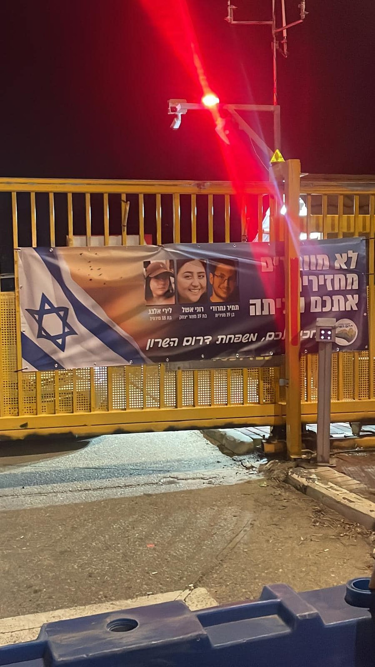 תמונה של כרזה למען שחרור החטופים תלויה בכניסות ליישובי המועצה השונים