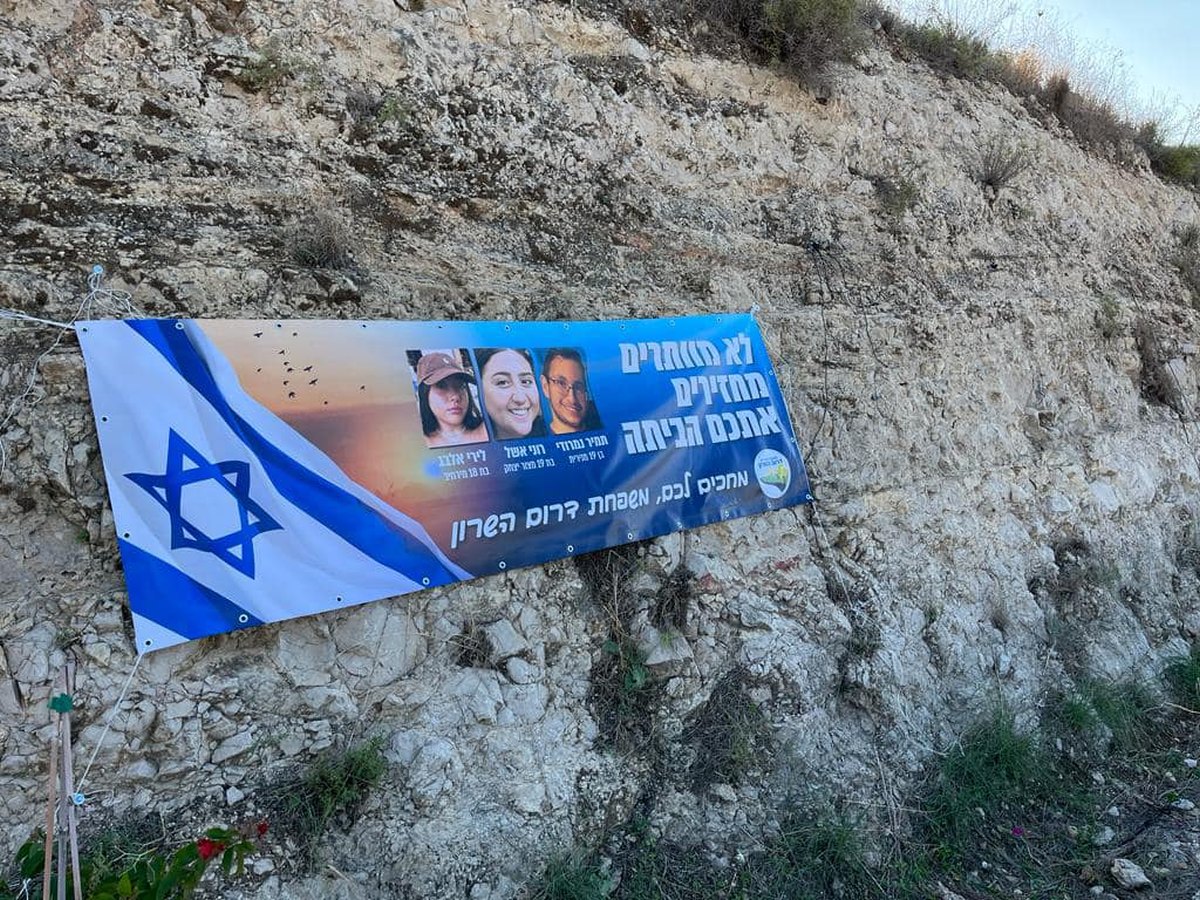תמונה של כרזה למען שחרור החטופים תלויה בכניסות ליישובי המועצה השונים
